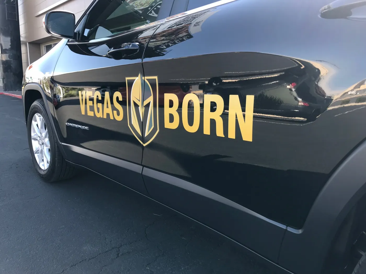 Gold cut lettering laid along the flank of a dark SUV — vinyl, not paint, and removable.