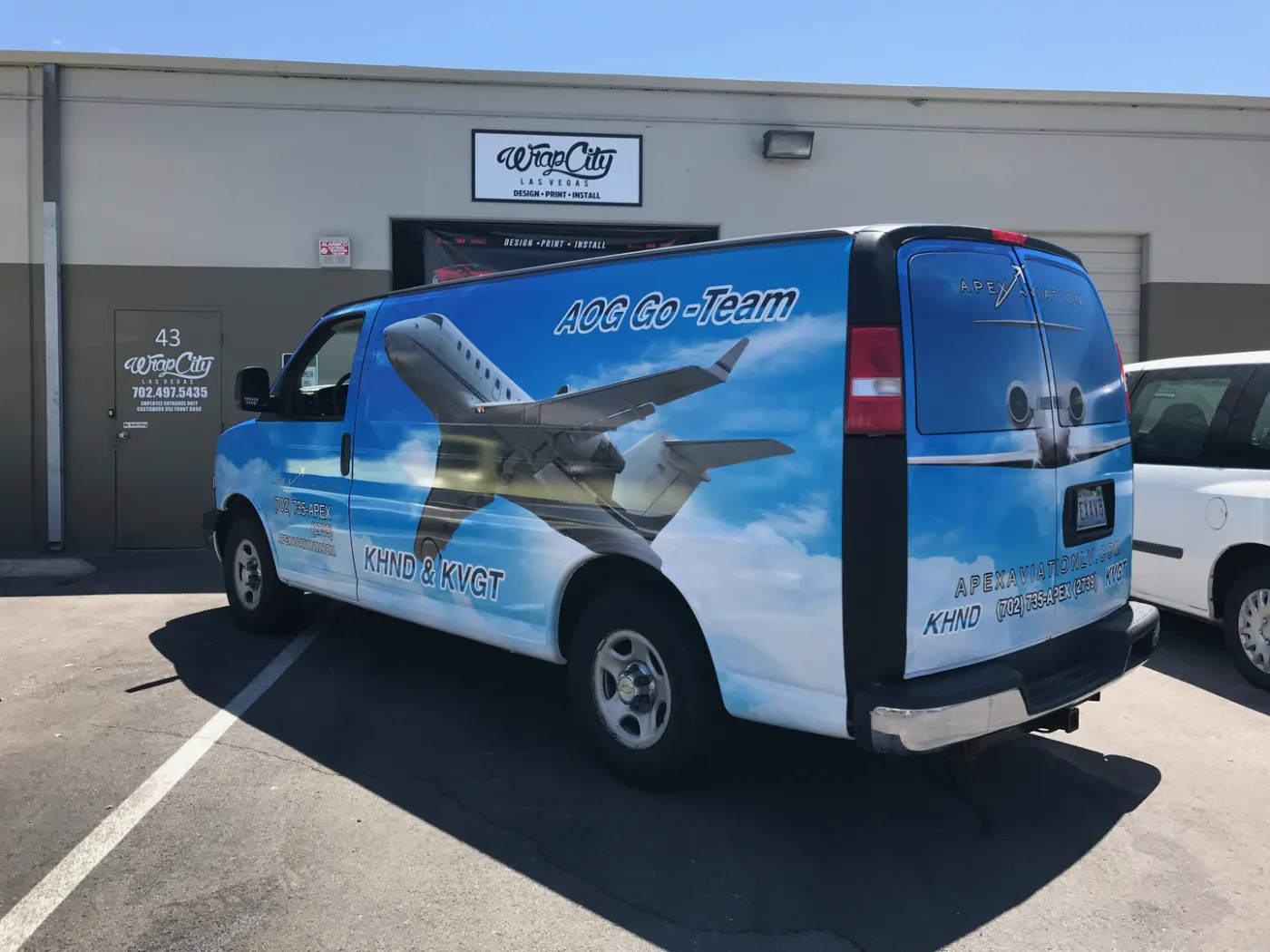 Cargo van carried edge to edge in a sky-and-aircraft print, with contact details worked into the rear doors.