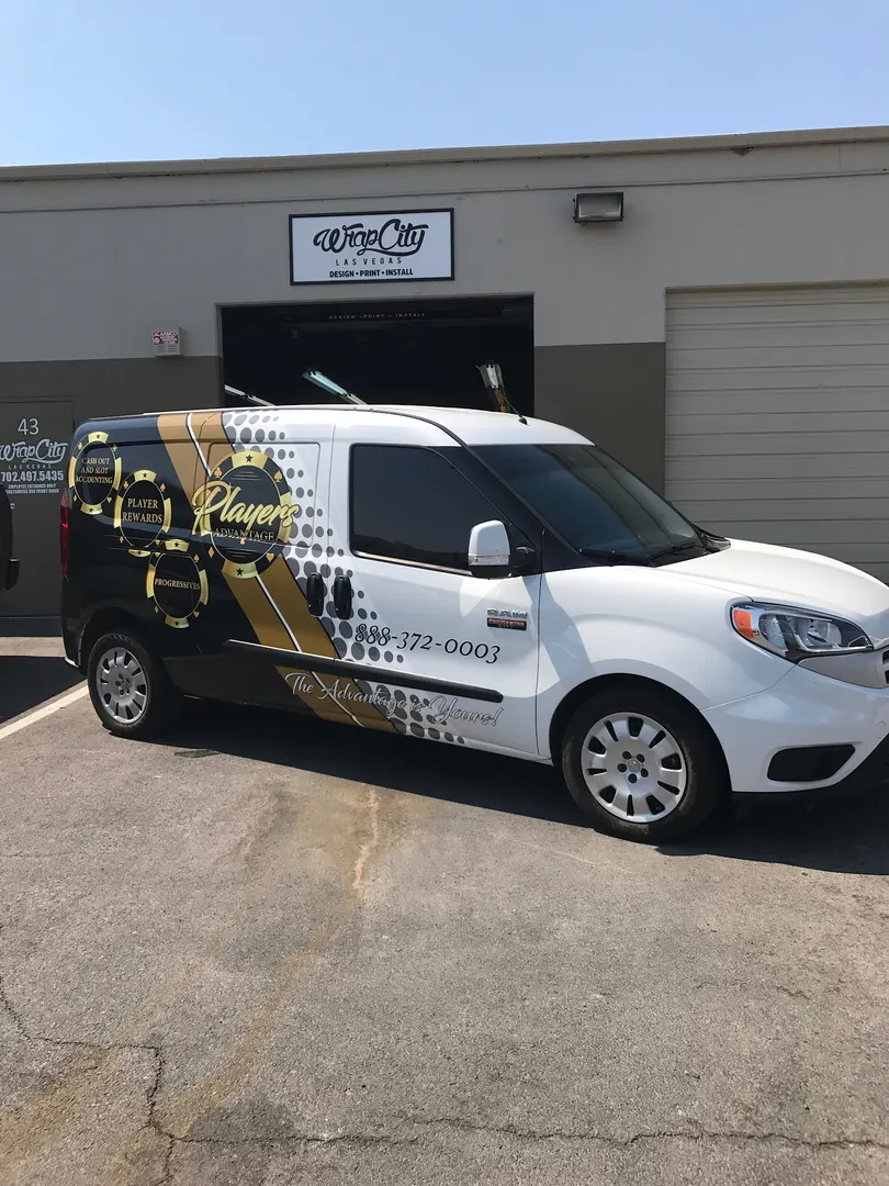 Compact cargo van in a black-and-gold halftone fade, graphics stopping short of the roof.