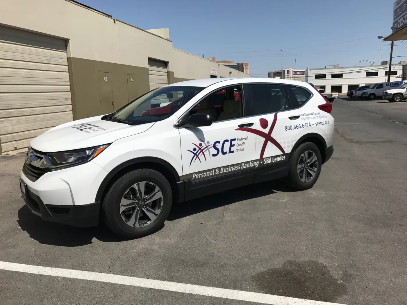 Compact SUV with door-panel graphics and a toll-free number — a light-touch wrap over factory paint.