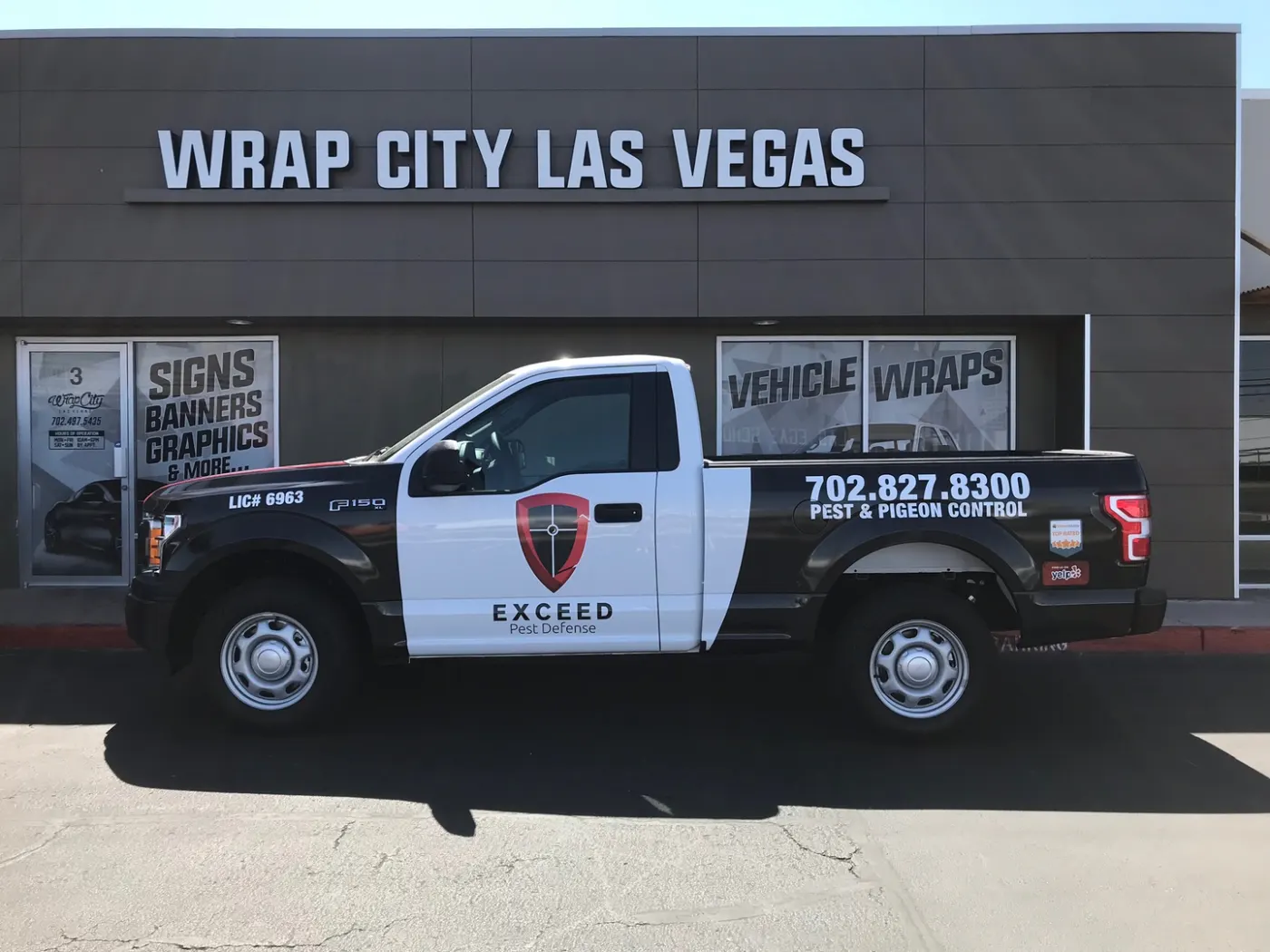 Pickup in fleet livery — printed shield, licence line and phone number sized to be read from another lane.
