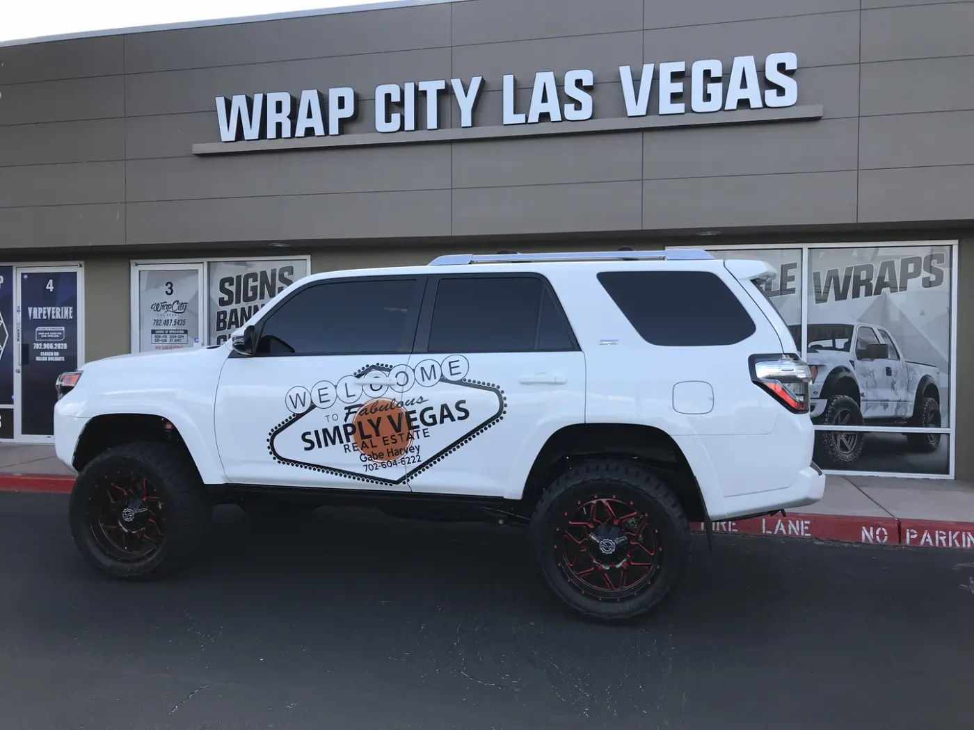 SUV with a printed welcome-sign graphic across both doors and blacked-out trim.
