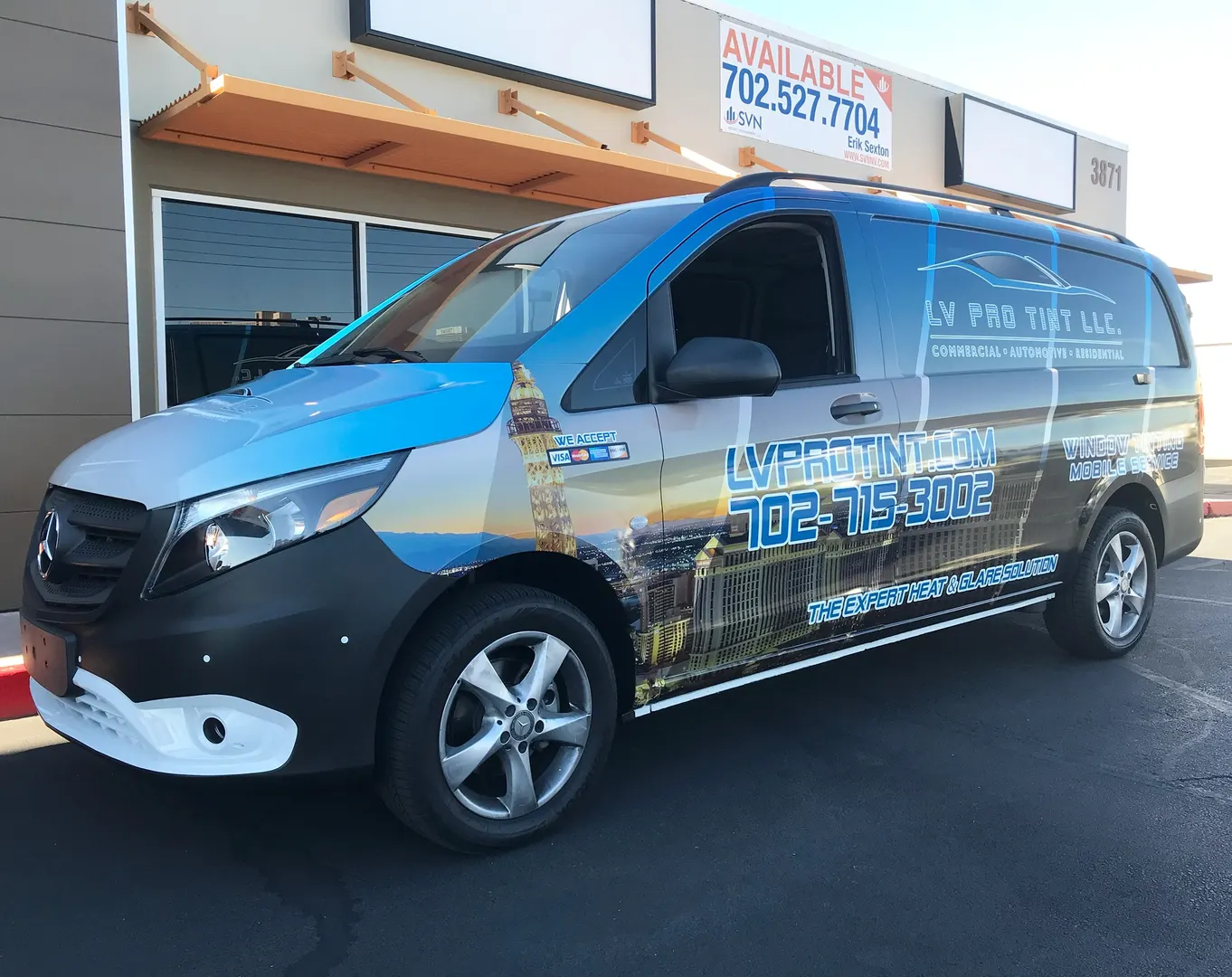 Passenger van in a printed skyline gradient — the kind of artwork that only works at full-panel scale.
