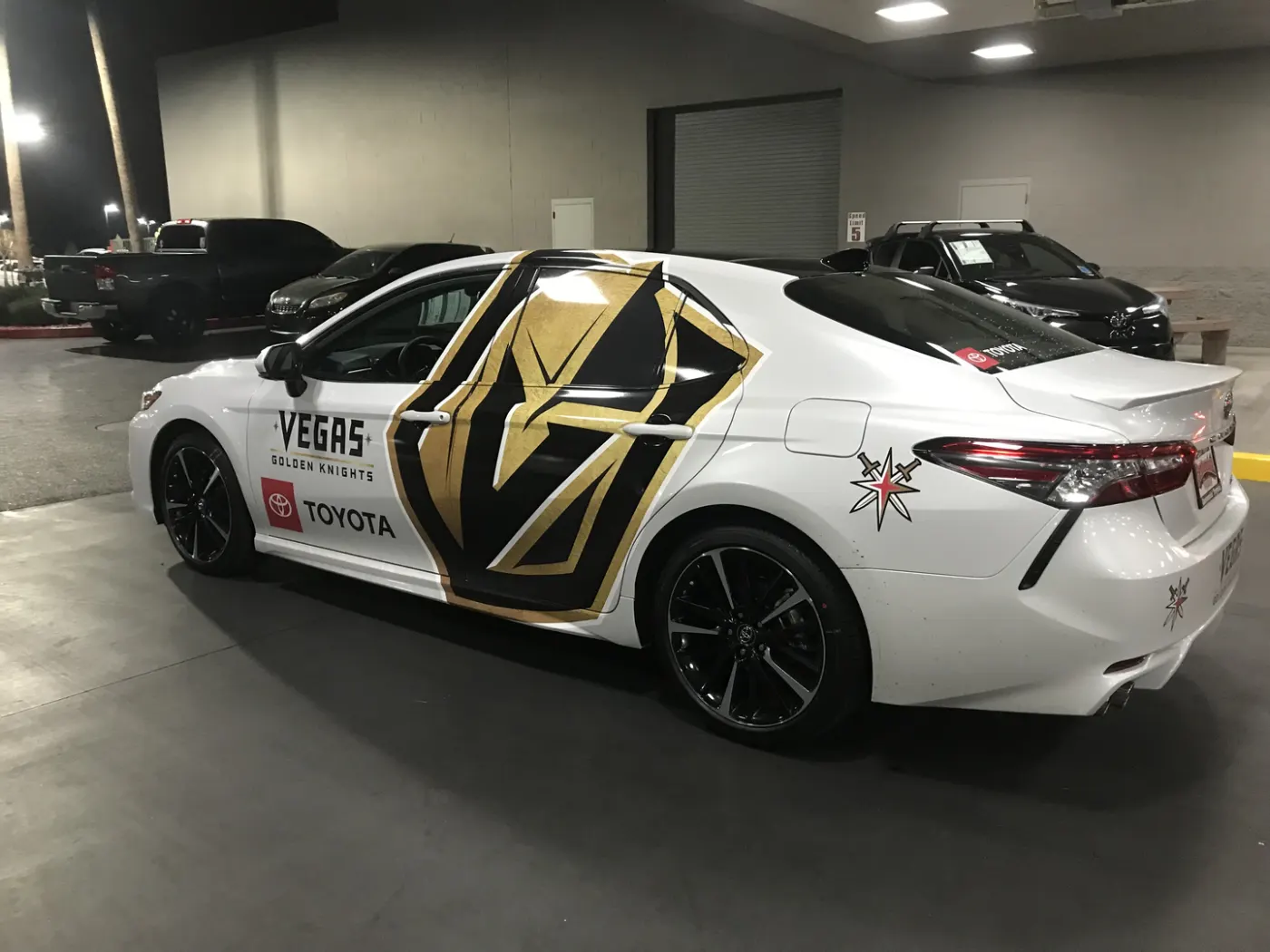 Sedan in a black-and-gold team livery, printed and cut to follow the body lines.