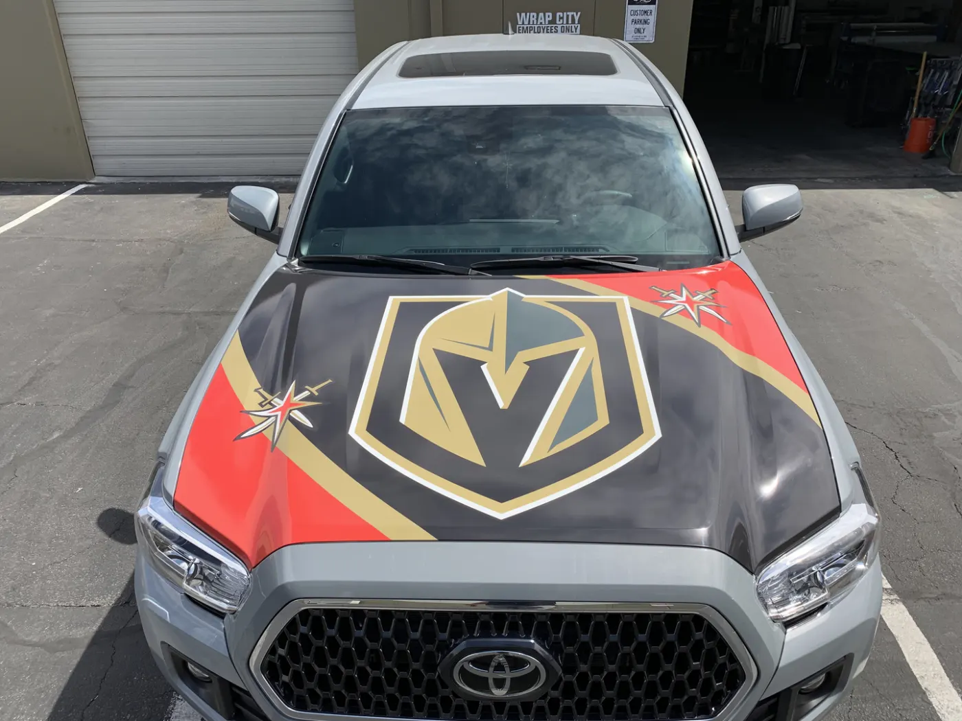 Large printed shield across a truck hood, colour carried into the fenders.